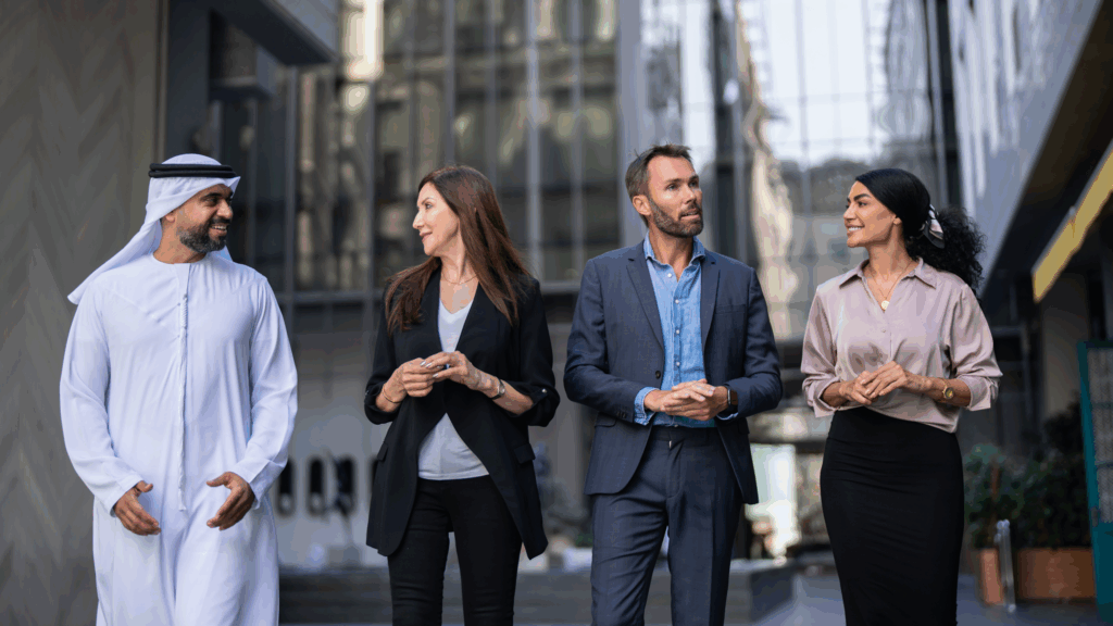 4 Students, in different styles of dress, walking and talking in a city.