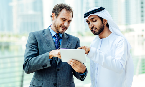 Two business people discuss plans outside.
