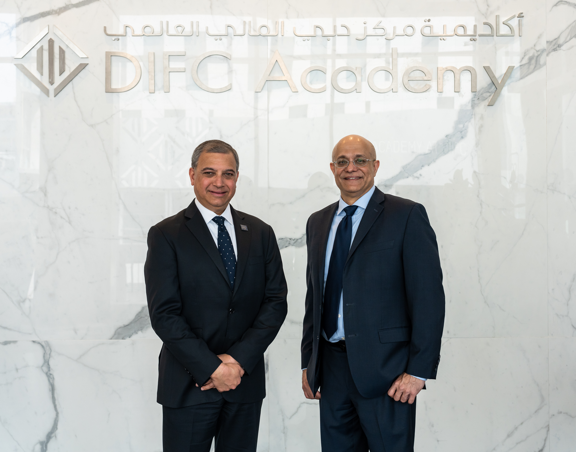 Dean Prashant Malaviya and Dean of the Business school at Georgetown stand in front of the DIFC sign. 