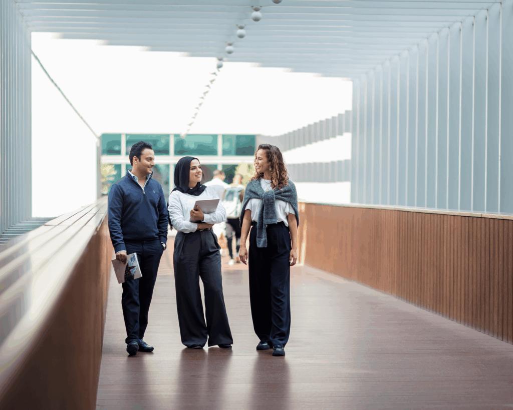 Georgetown Dubai IBP students conversing while walking in a hallway.